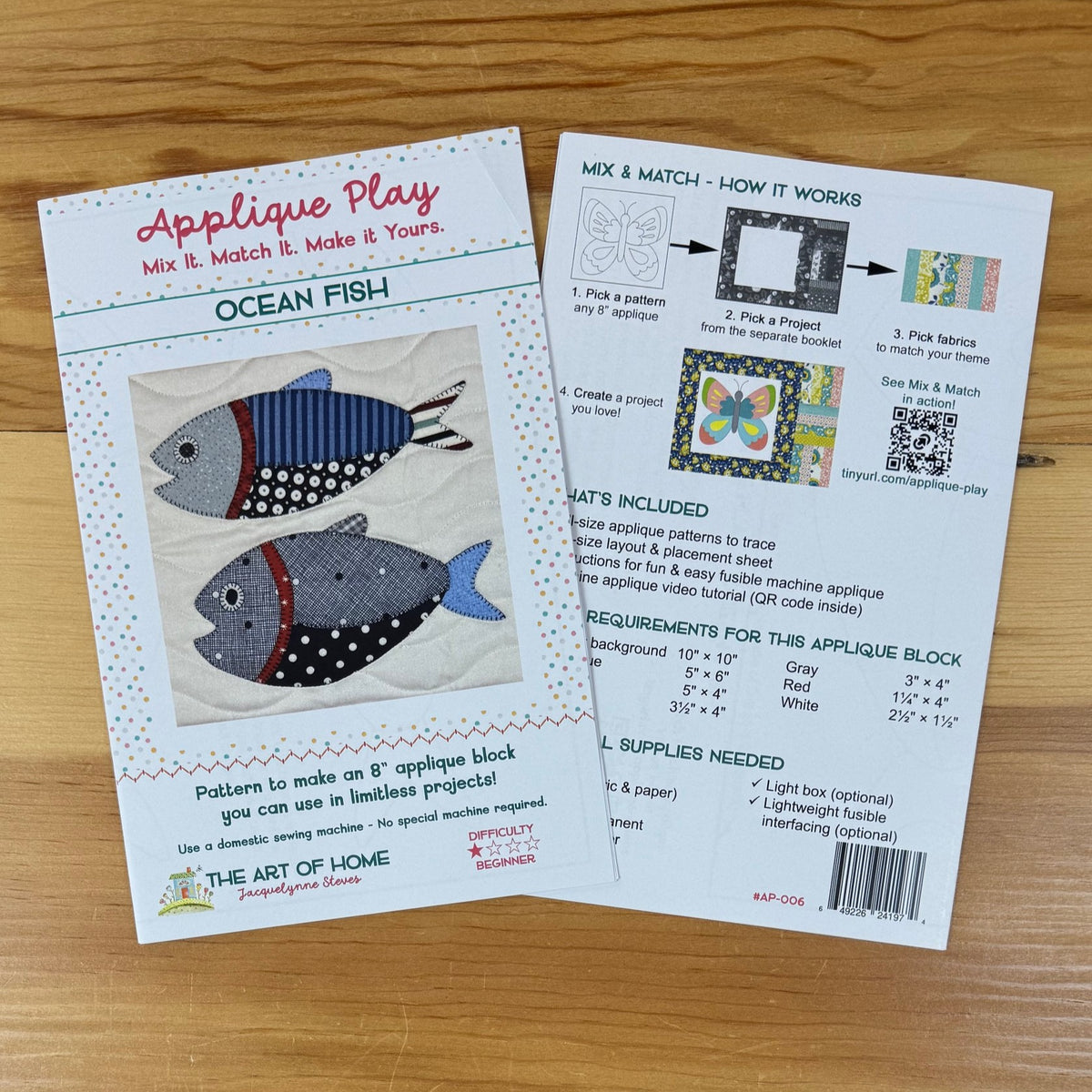 Front and back covers for a sewing/quilting applique pattern titled "Applique Play" and "Ocean Fish," placed on a light wood surface. The cards show illustrated fish designs, step-by-step usage instructions, included supplies, and a barcode.