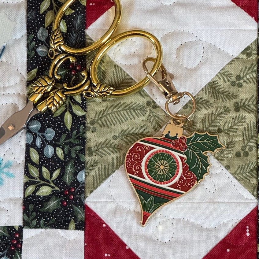 Gold scissors with Christmas Ornament charm on quilt