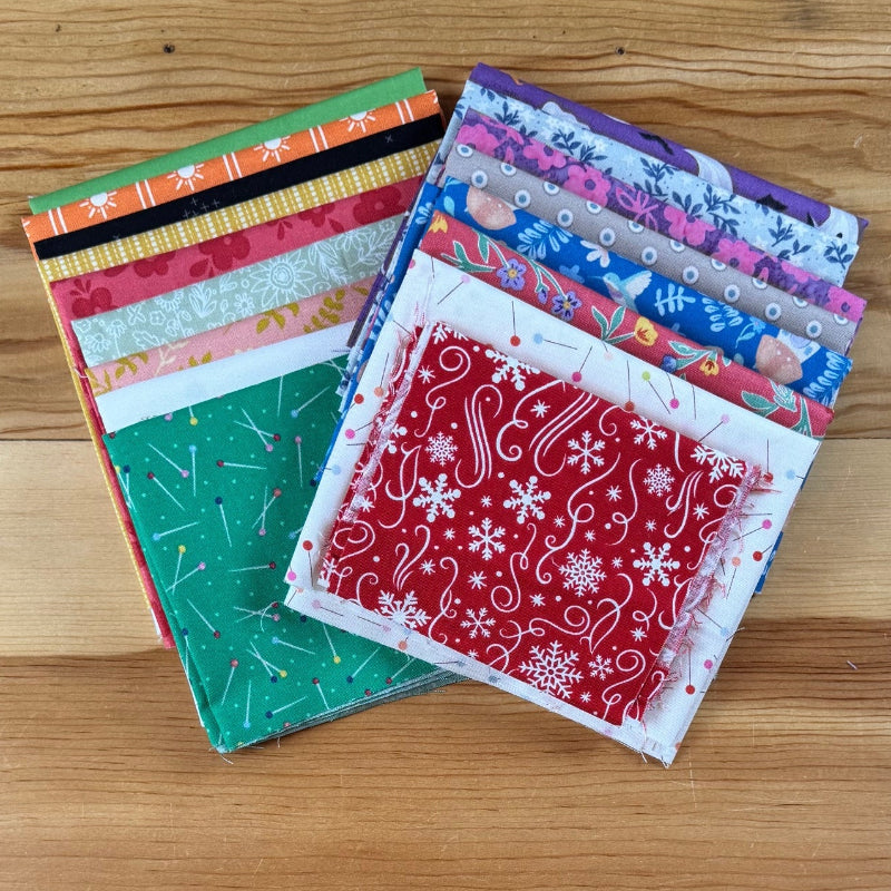 Stack of colorful fabric squares on a wooden surface.