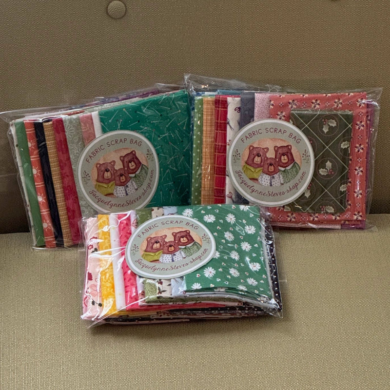 Three packages of fabric with colorful patterns on a beige surface.