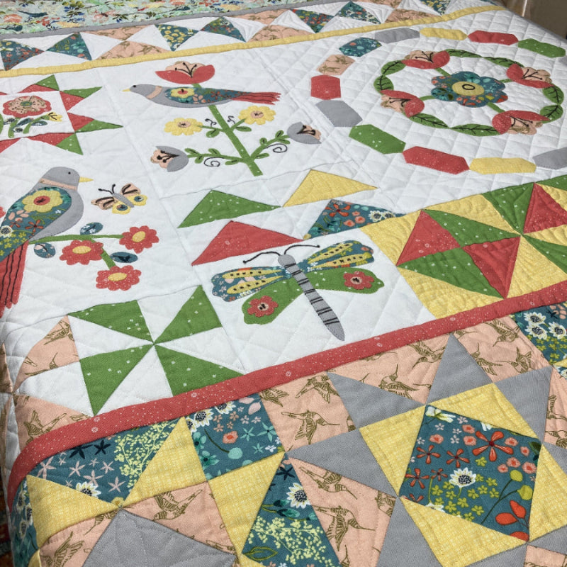 Songbird's Garden Block of the Month colorful quilt with geometric patterns and nature-themed designs.