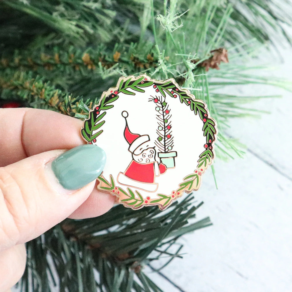 Christmas-themed Vintage Santa Magnetic Needle Minder on a green leafy background.