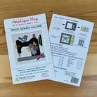 Front and back covers of 'Applique Play' for a 'Birdie Sewing Machine' by The Art of the Home, shown on a wooden tabletop. The front cover features a colorful applique design of a bird and flower, while the back cover displays step-by-step instructions and a requirements list.