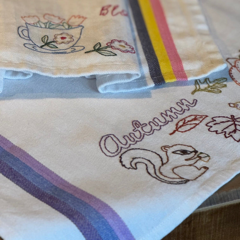 Two hand-embroidered striped tea towels