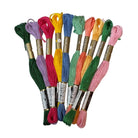 Assorted colorful embroidery threads on a white surface