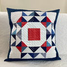 Quilted pillow with geometric pattern on a white couch