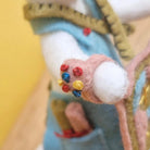 Close-up of a hand with a colorful pin cushion on a blurred background