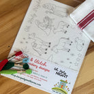 Oh Holy Night Stick & Stitch featuring nativity characters and animals and verbiage.  Also shows red stripe tea towel and embroidery floss on a wood table.