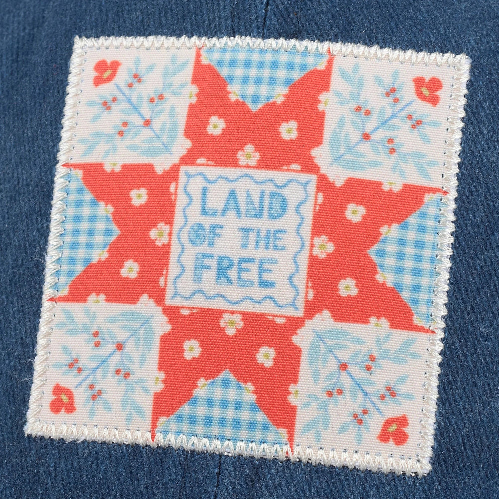 red, white, and blue quilt block design saying Land of the Free.
