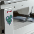 A Janome sewing machine with a heart-shaped sticker that says I Love Sewing.