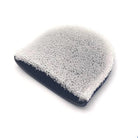 Navy blue scrubber with white granular surface on a white background