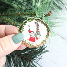 Christmas-themed Vintage Santa Magnetic Needle Minder on a green leafy background.