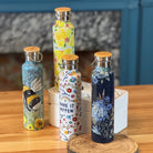 Set of decorative water bottles on a wooden surface with a blurred background