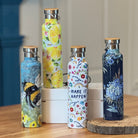 Set of colorful water bottles on a wooden table with a neutral background