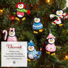 Decorative penguin ornaments on a Christmas tree with festive lights.